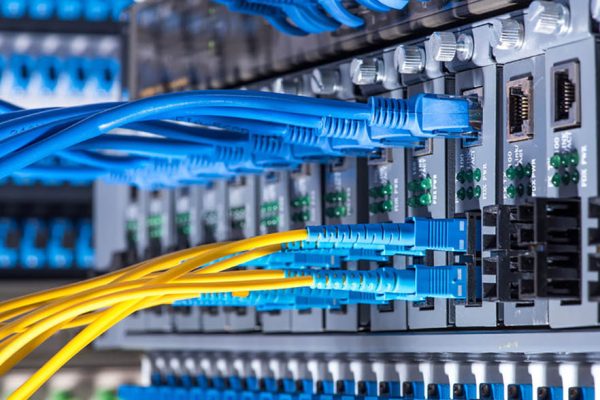 51208443 - fiber optic cables connected to an optic ports and network cables connected to the ports